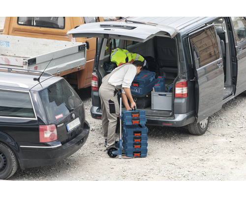 Ambachtsman laadt een bestelwagen met Bosch gereedschapskoffers