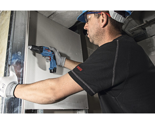 Ambachtsman bevestigt gipsplaat met een accuboormachine voor gipsplaten