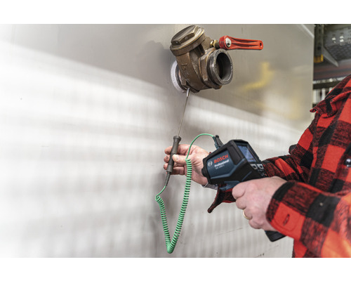 Een persoon gebruikt een Bosch warmtebeeldcamera om de temperatuur van een ventiel te meten.