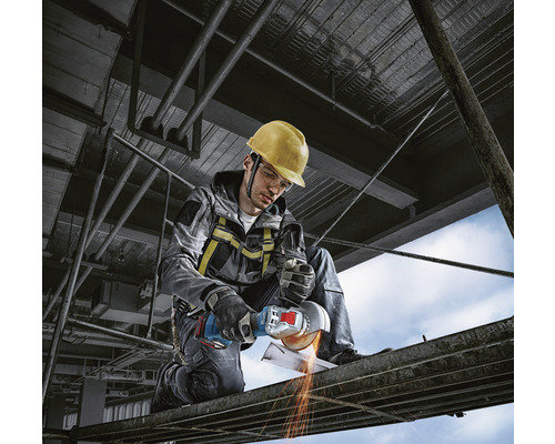 Man met veiligheidshelm en haakse slijper die metaal snijdt op een bouwplaats