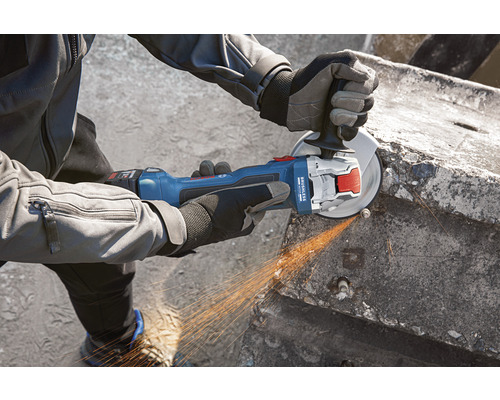 Een persoon gebruikt een accuslijper om beton te slijpen.