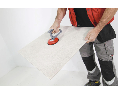 Man hanteert tegelzuignap en tegel