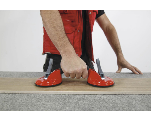 Tegelzuignap in gebruik voor het heffen van een tegel