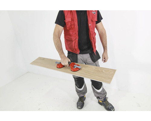 Man draagt tegel met zuignapgereedschap