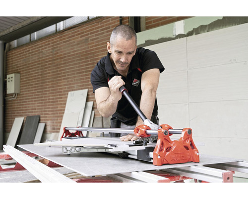 Vakman snijdt tegels met een tegelsnijder