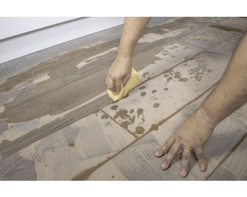 Reiniging van vloertegels met een spons.