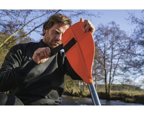 Man bevestigt peddel aan kajak droogpak voor outdoor watersport