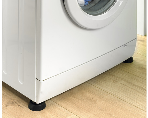 Wasmachine met anti-vibratievoeten op houten vloer