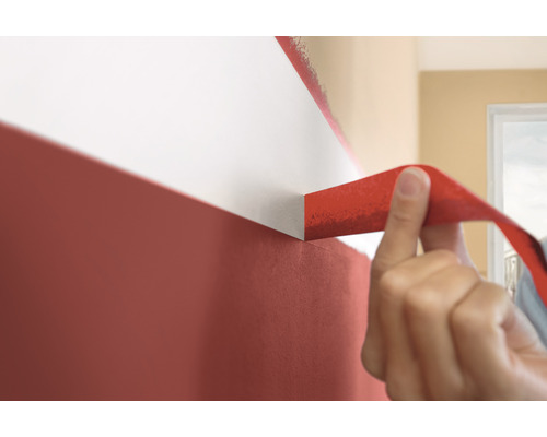 Afplaktape wordt van een muur met twee kleuren verwijderd