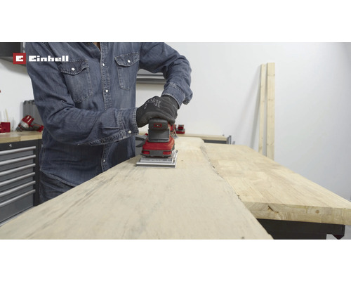 Een persoon schuurt hout met een schuurmachine van Einhell.