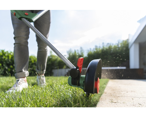 Gras trimmer in gebruik voor het snijden van de randen van een gazon