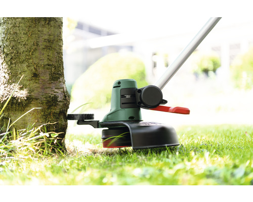 Grasmaaier in gebruik bij een boom