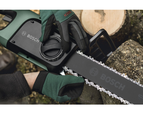 Bosch logo op een accu kettingzaag, die wordt vastgehouden door twee gehandschoende handen