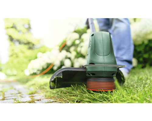 Gras trimmer in gebruik op een gazon.