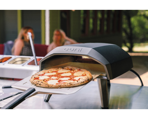 Ooni pizzaoven met pizza op een pizzaschep