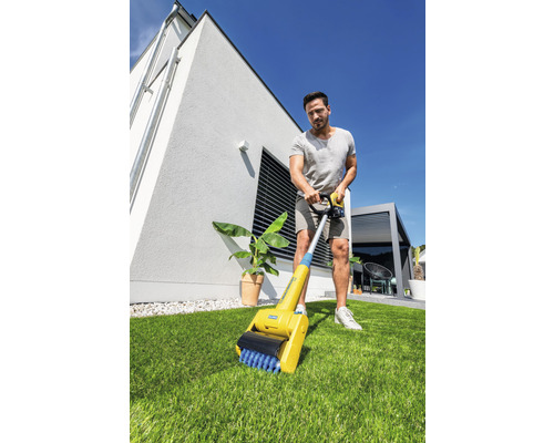 Man gebruikt een voegenborstel in de tuin