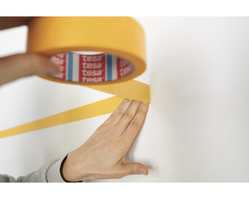 Afplakband wordt op een muur aangebracht