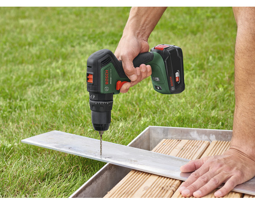 Een persoon boort een gat in een stuk metaal met een accuboormachine. Bosch logo.