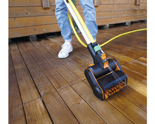 Terrasreiniger in gebruik op een houten terras met persoon
