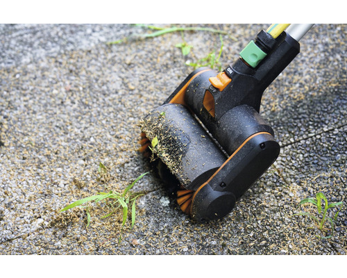 Voegenborstel in gebruik op straatstenen voor onkruidverwijdering