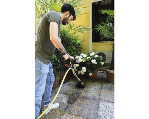 Man reinigt terras met een terrasreiniger.