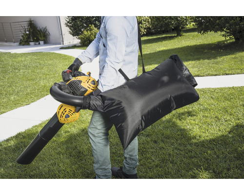 Persoon met bladblazer en opvangzak in de tuin