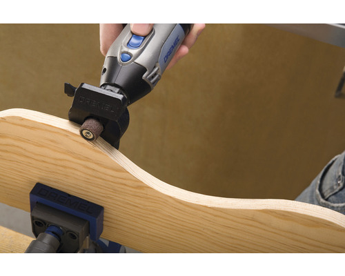 Dremel multifunctioneel gereedschap dat een stuk hout schuurt dat in een bankschroef is bevestigd