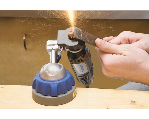 Dremel gereedschapslijper met werkstuk in de hand