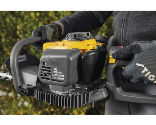 Persoon houdt een gele en grijze heggenschaar vast