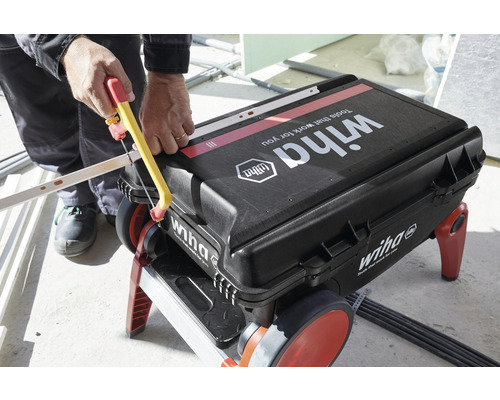 Iemand zaagt een werkstuk op een Wiha gereedschapskist.