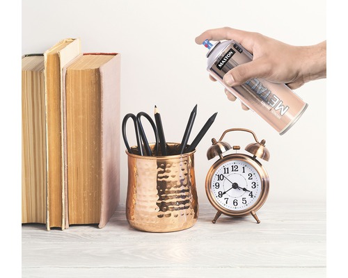 Scene met boeken, pennenhouder met pennen, wekker en spuitbus metaallak