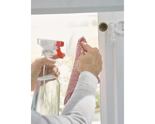 Een ruit schoonmaken met een spuitfles en een doek