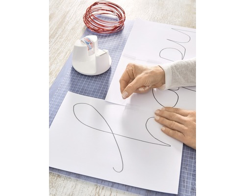 Knutselopstelling met draad, sjablonen, plakbanddispenser en snijmat voor doe-het-zelfprojecten.