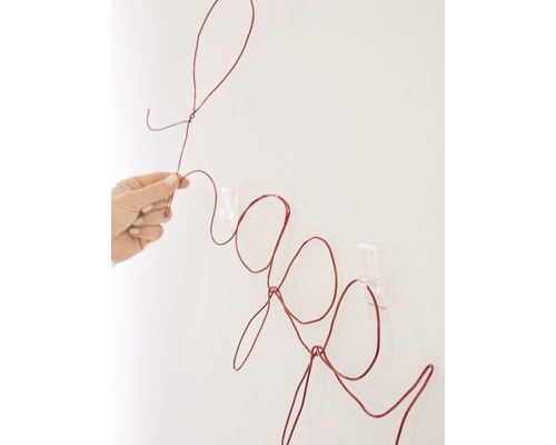 Decoratieobject in de vorm van het woord vraag van draad aan de muur bevestigd