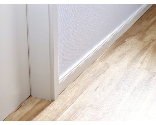 Gedetailleerd beeld van een kamer met een laminaatvloer, een witte plint en een deurkozijn