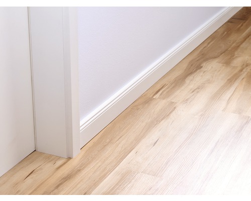 Detailopname van een kamer met plinten en laminaatvloer.