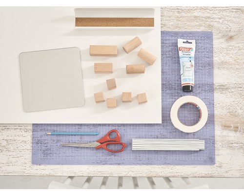 Knutselspullen op een werkblad met snijmat, lijm, houten blokken en gereedschap