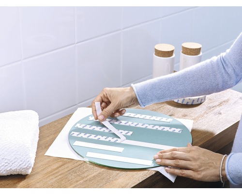 Spiegelmontagetape aanbrengen op een ronde spiegel in de badkamer