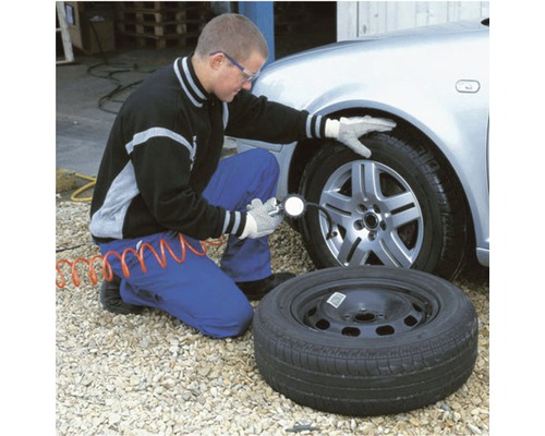 "Man controleert bandenspanning met meetapparaat aan auto