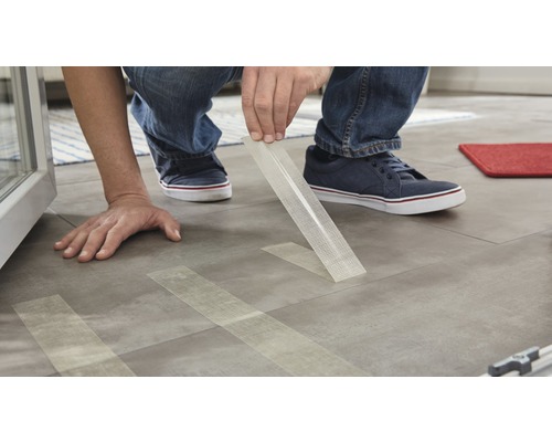 Persoon legt designvloer met dubbelzijdige tape