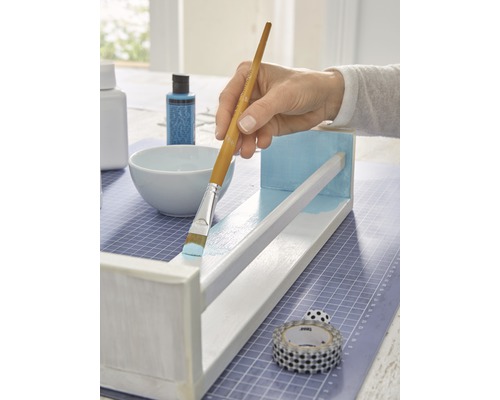 Een houten plank schilderen met een penseel en verf