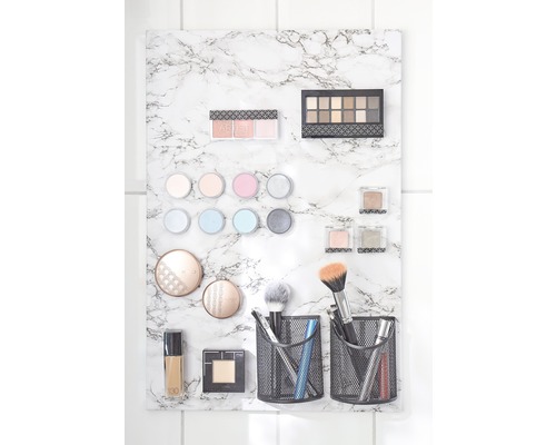 Cosmetische producten bevestigd op een marmeren plaat, inclusief oogschaduwpaletten, make-upborstels en vloeibare foundation