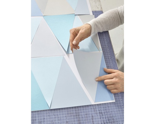 Persoon rangschikt driehoekige behangpatronen