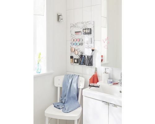 Lichte badkamer met wastafel, spiegel en witte stoel met handdoek