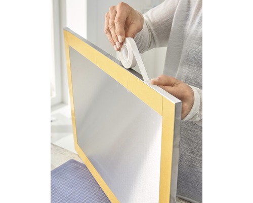 Dubbelzijdige tape wordt aangebracht op een zilverkleurig frame