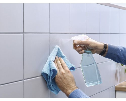 Tegels schoonmaken met een spuitfles en doek