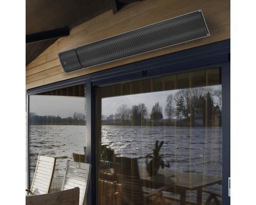 Aan het plafond gemonteerde terrasverwarmer boven een glazen pui met uitzicht op een meer