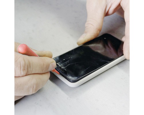 Persoon repareert een smartphone met een schroevendraaier.