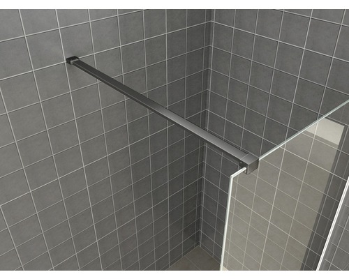 Detailopname van een douchecabine met een grijs betegelde wand en een steunbalk.