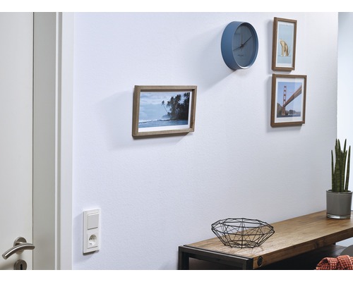 Woonkamer met wandklok en ingelijste foto''s